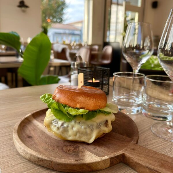 Un appétissant burger savoyard garni de fromage à ralcette fondu, steak haché et frites maison